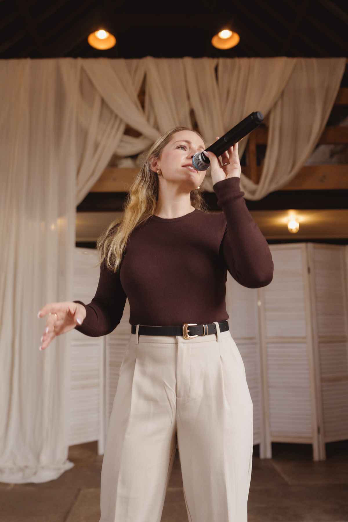 Abigail singing in a draped barn venue